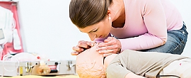 Frau übt Erste-Hilfe an Puppe