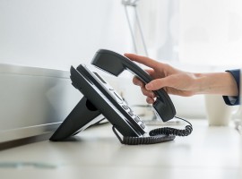 Person nimmt Telefonhörer ab Person nimmt Telefonhörer ab