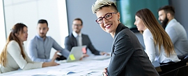 mehrere Menschen in Businesskleidung an einem Tisch