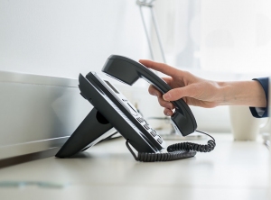 Person nimmt Telefonhörer ab Person nimmt Telefonhörer ab