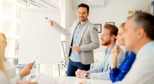 Seminar - Prävention – durch „Soziales Lernen“ Mann steht im Meeting vor Flipchart