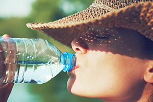 Wassertrinkende Frau im Sommer